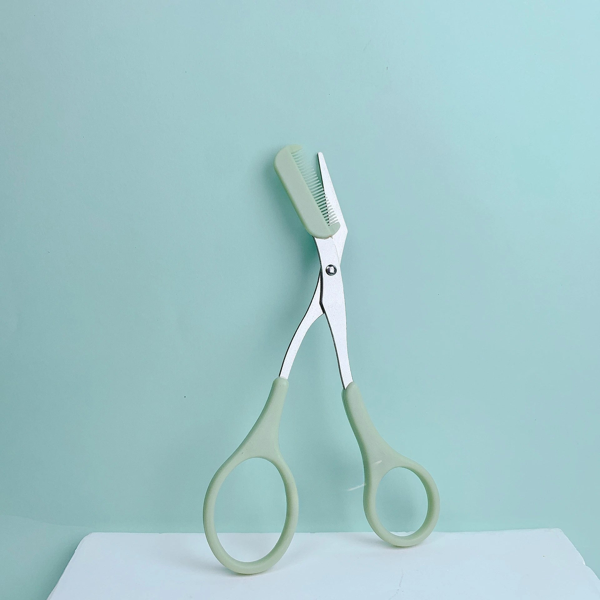 Eyebrow trimming scissors with built-in comb.