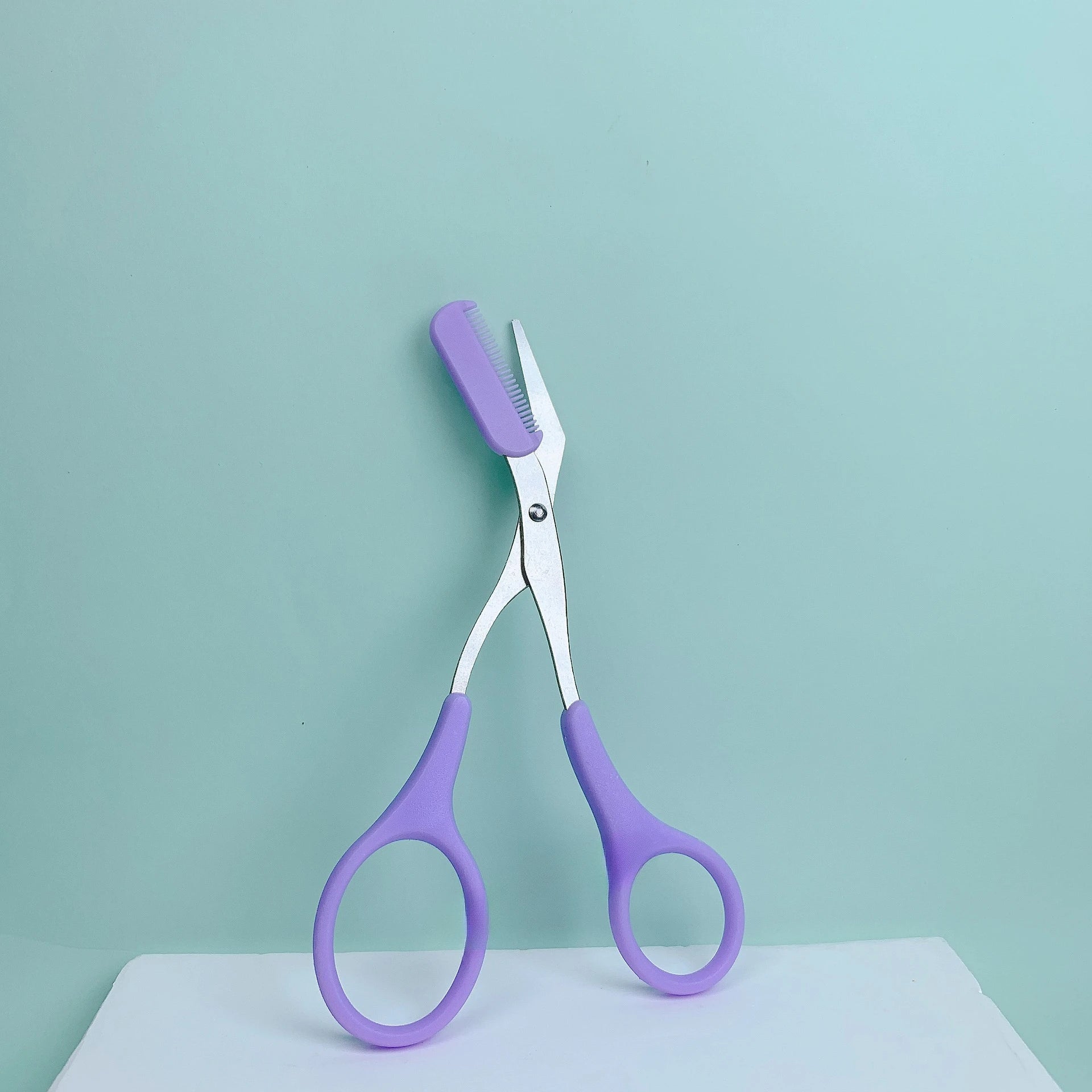 Eyebrow trimming scissors with built-in comb.